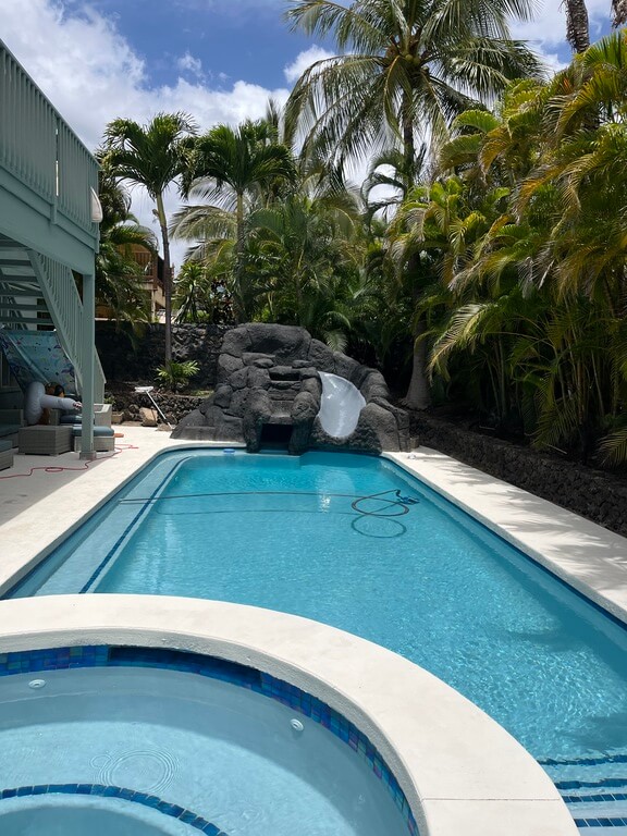 Decorative overlay on a pool slide and coating on pool deck